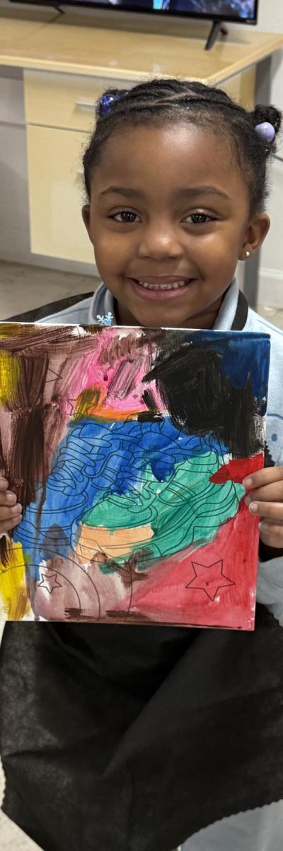Child holding their artwork.