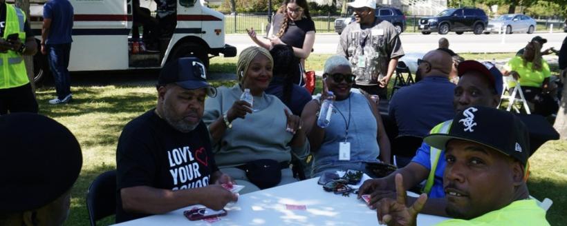 Community members sitting around a table smiling and talking